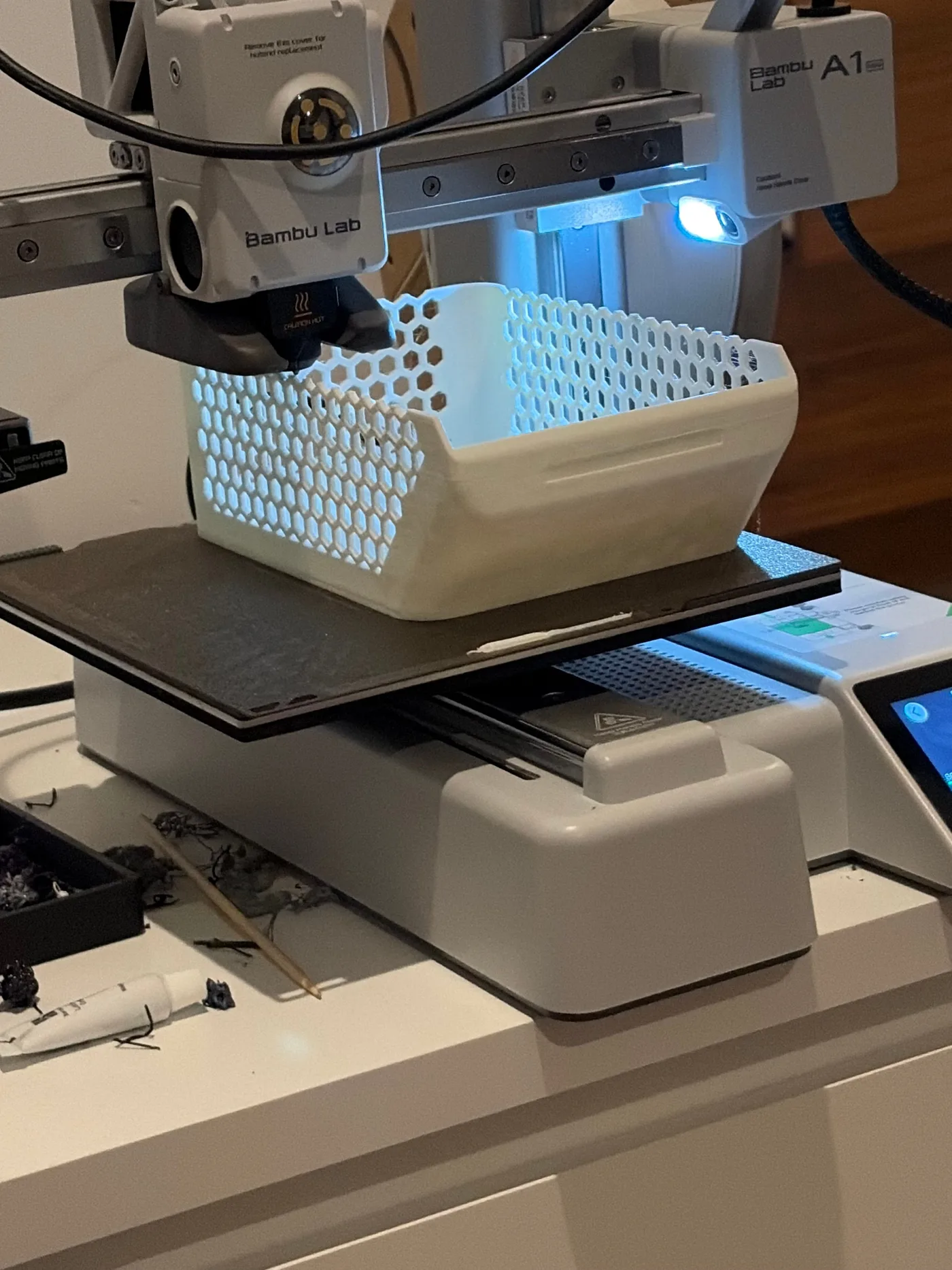 Bambu Lab A1 Mini beside early white functional 3D printed organization parts