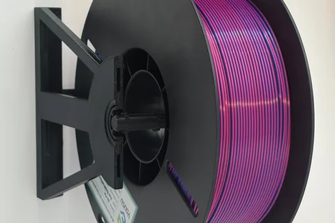 Purple filament spool mounted horizontally in a black 3D printed modular spool holder