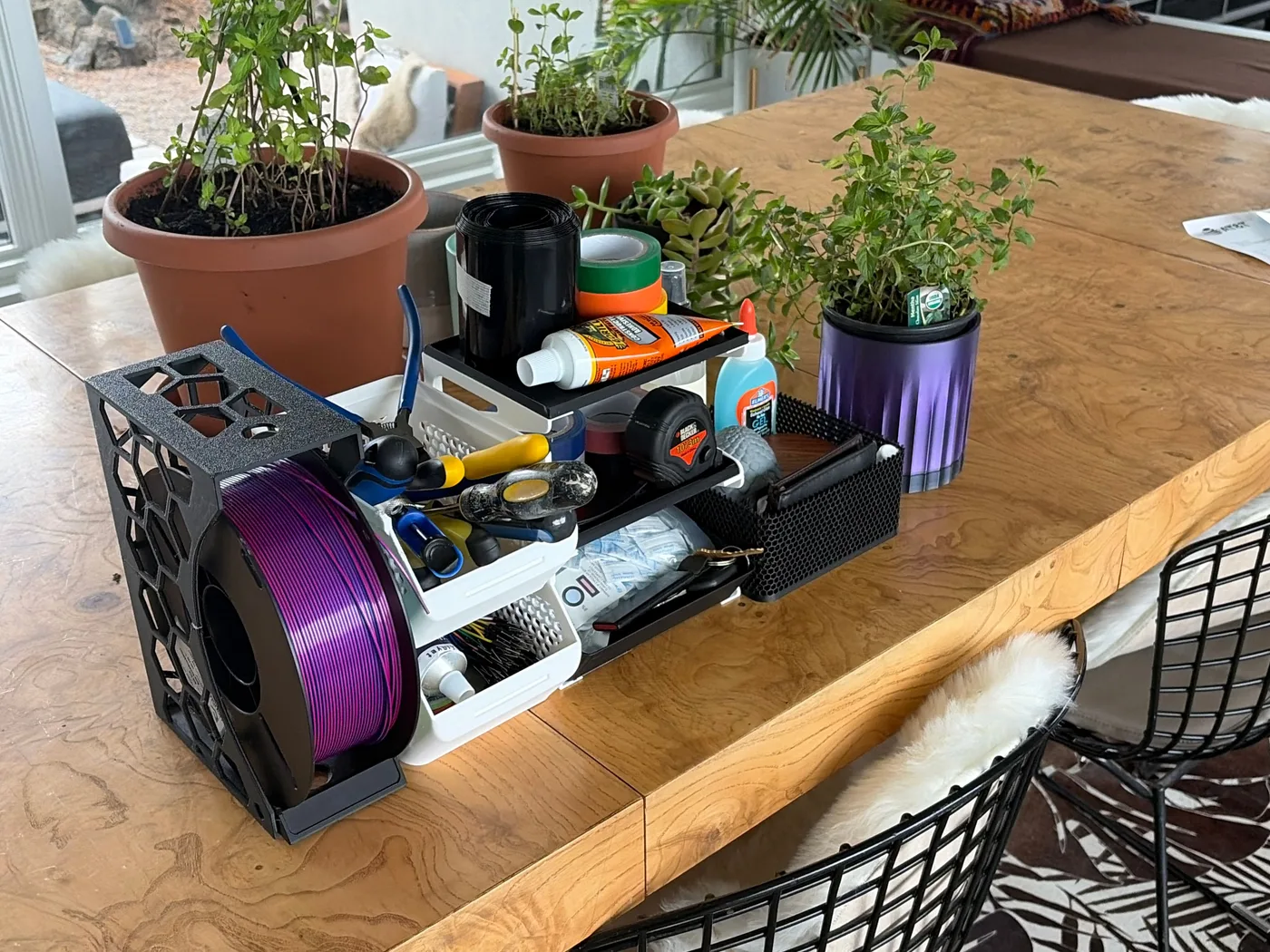 3D printing workspace with filament, tools, printed organizers, and a Bambu Lab A1 Mini