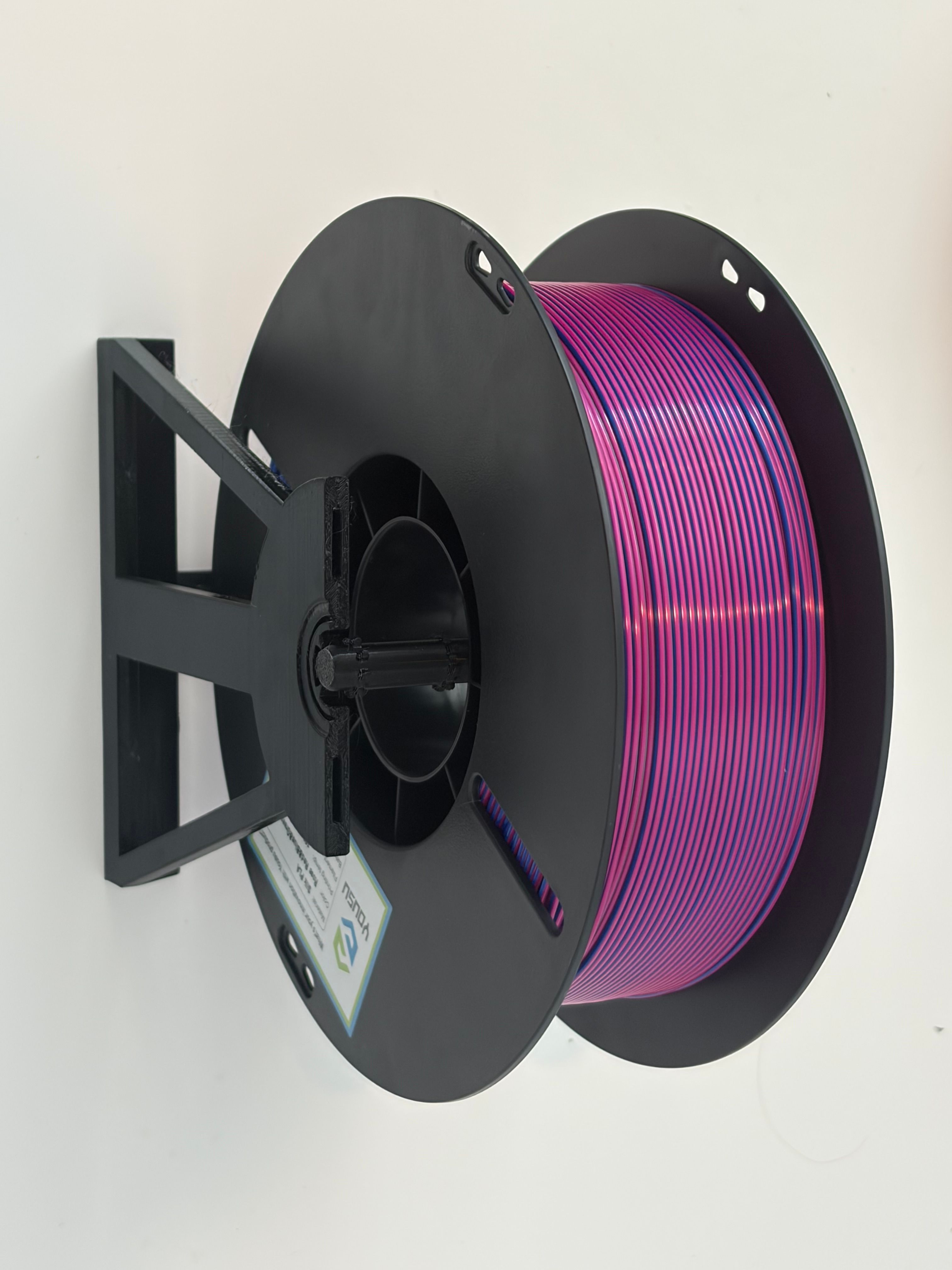Purple filament spool supported by a black 3D printed modular spool holder