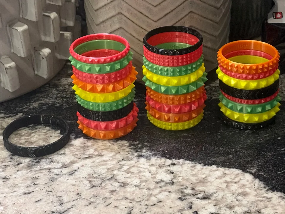 Multiple colorful 3D printed flexible bracelets arranged in rows
