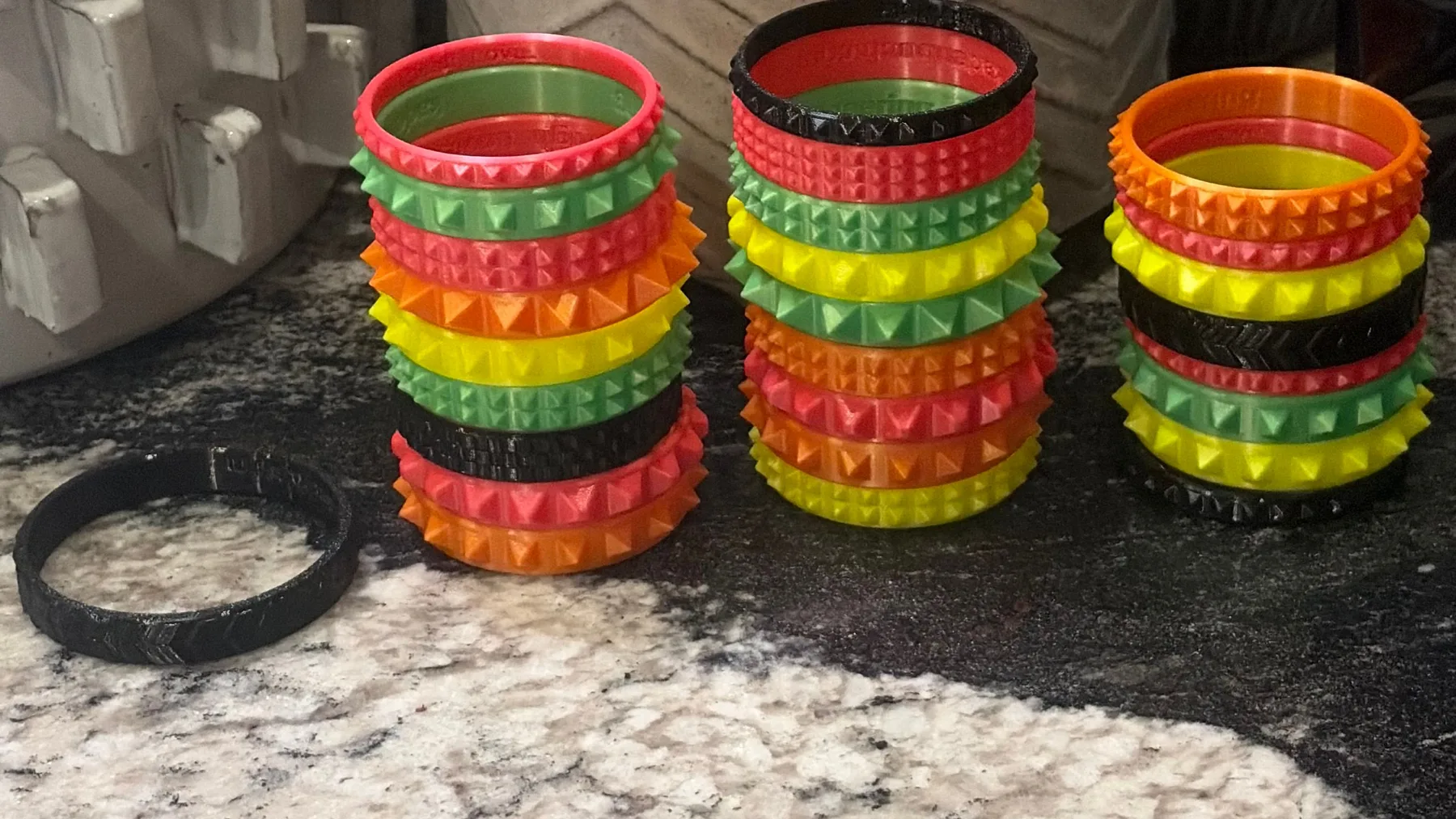 Multiple colorful 3D printed flexible bracelets arranged in rows