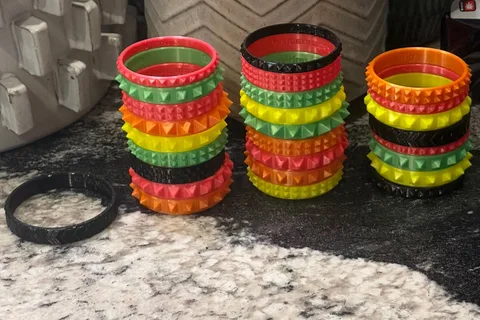 Multiple colorful 3D printed flexible bracelets arranged in rows
